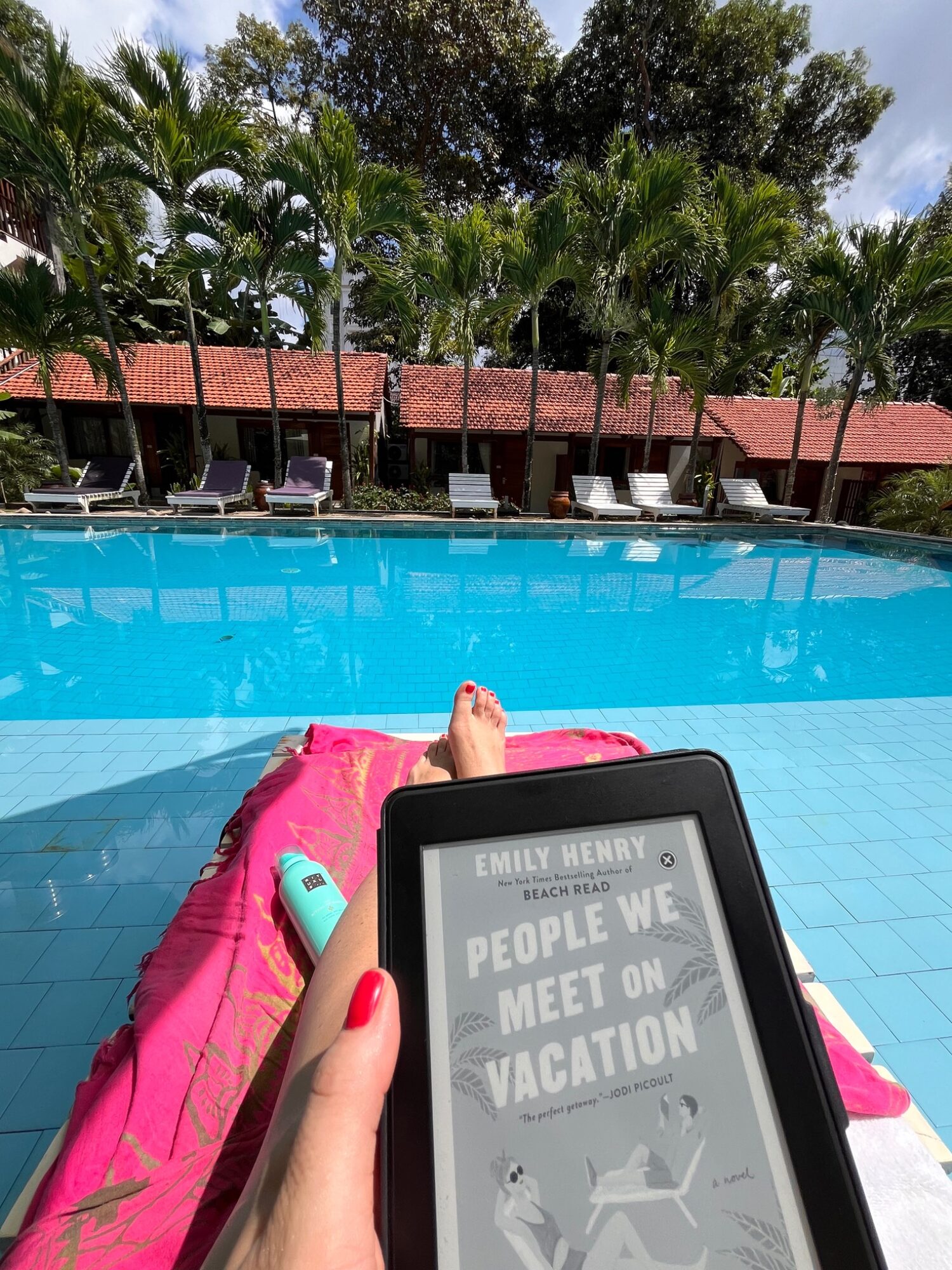 People We Meet on Vacation book held beside a sunny pool