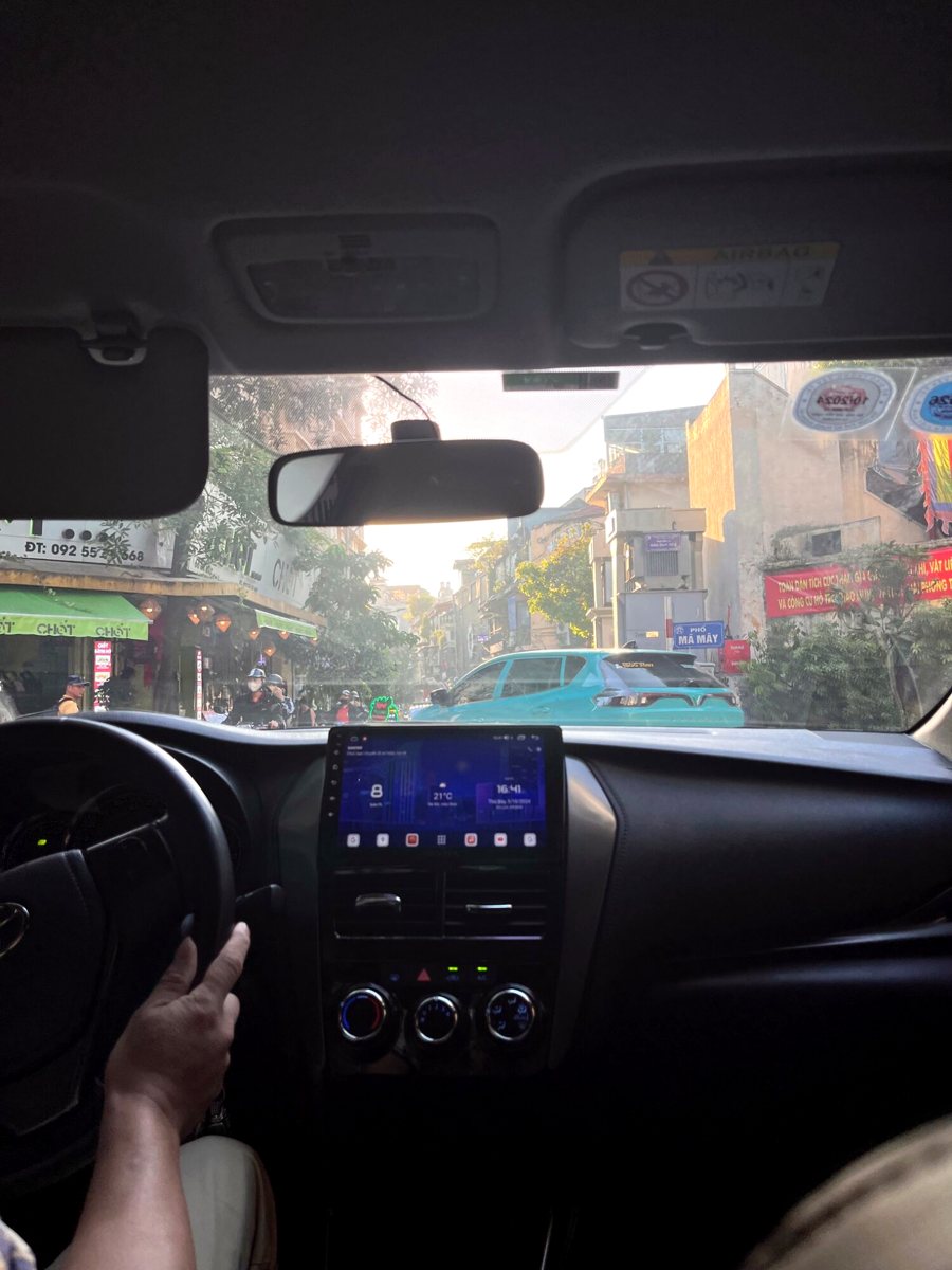 View through a taxi windshield onto a busy Old Quarter street