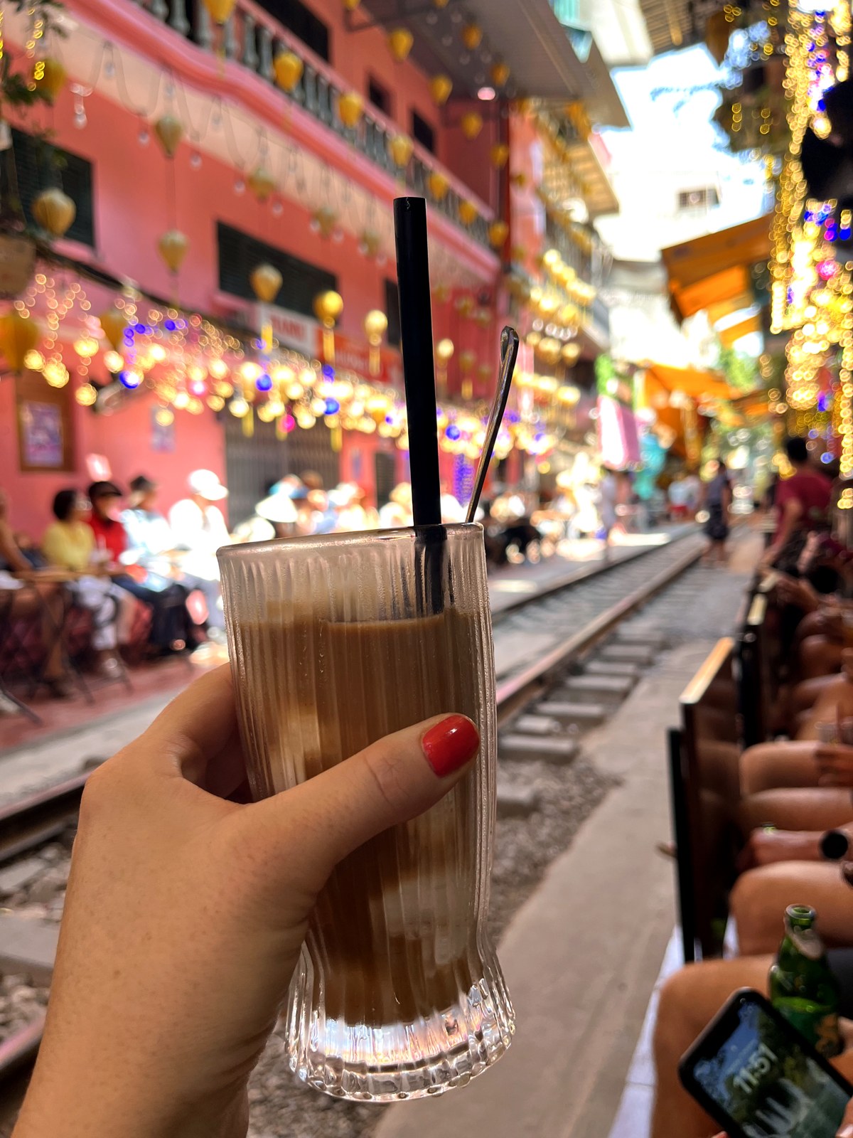 Coconut coffee held above the tracks at a Hanoi Train Street café