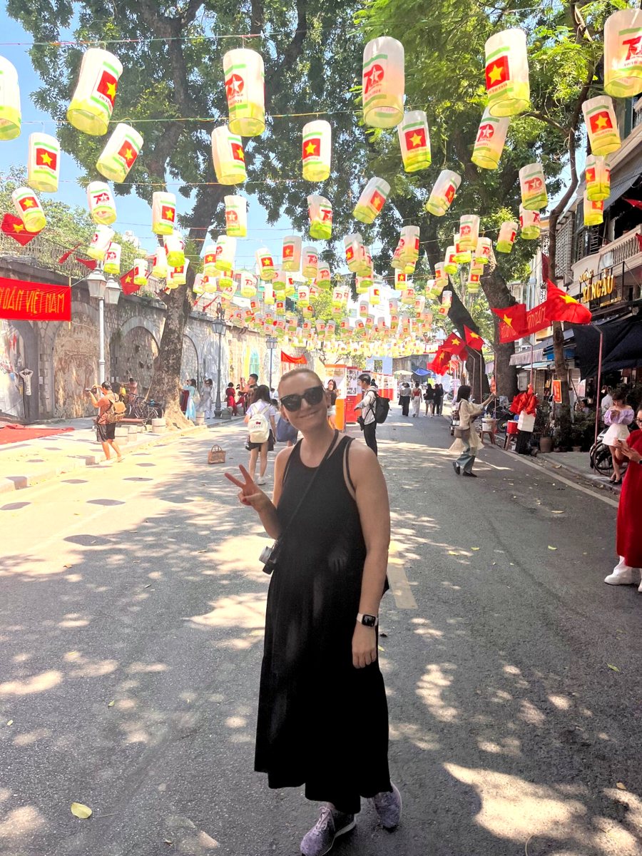 Traveller under hanging lanterns and Vietnamese flags on a Hanoi street