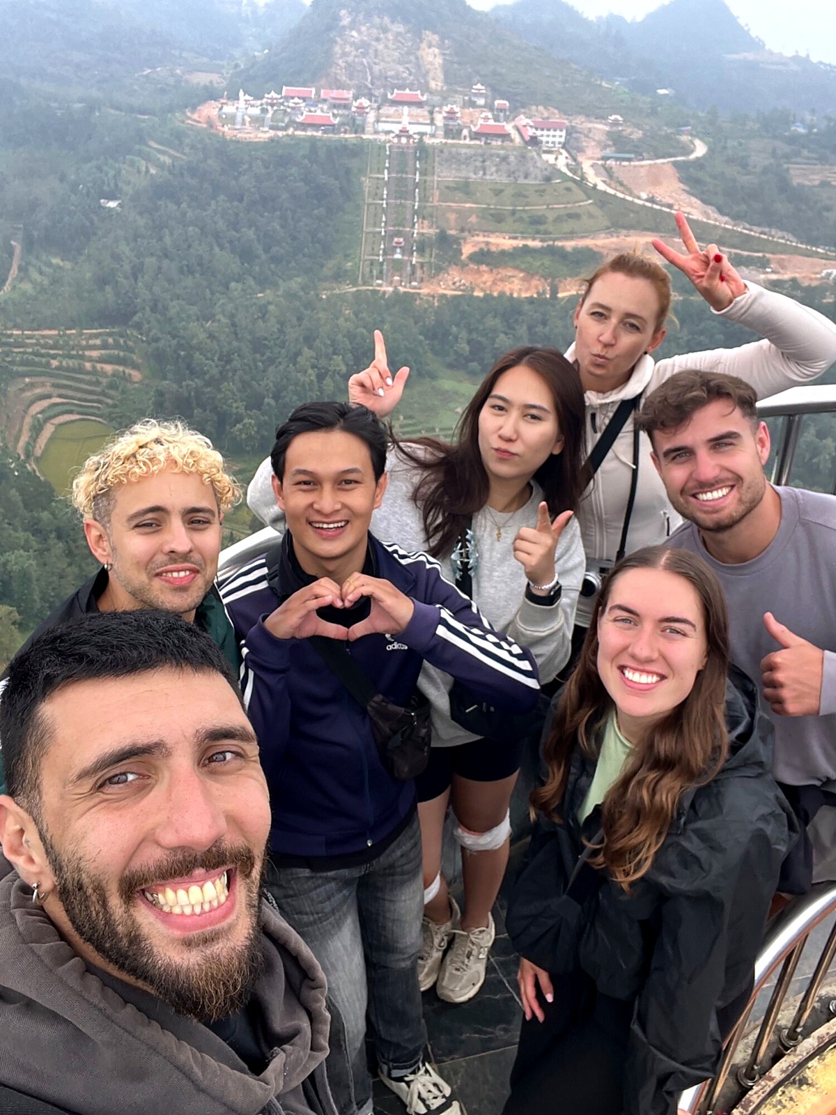 The travel group taking a selfie together above a mountain valley