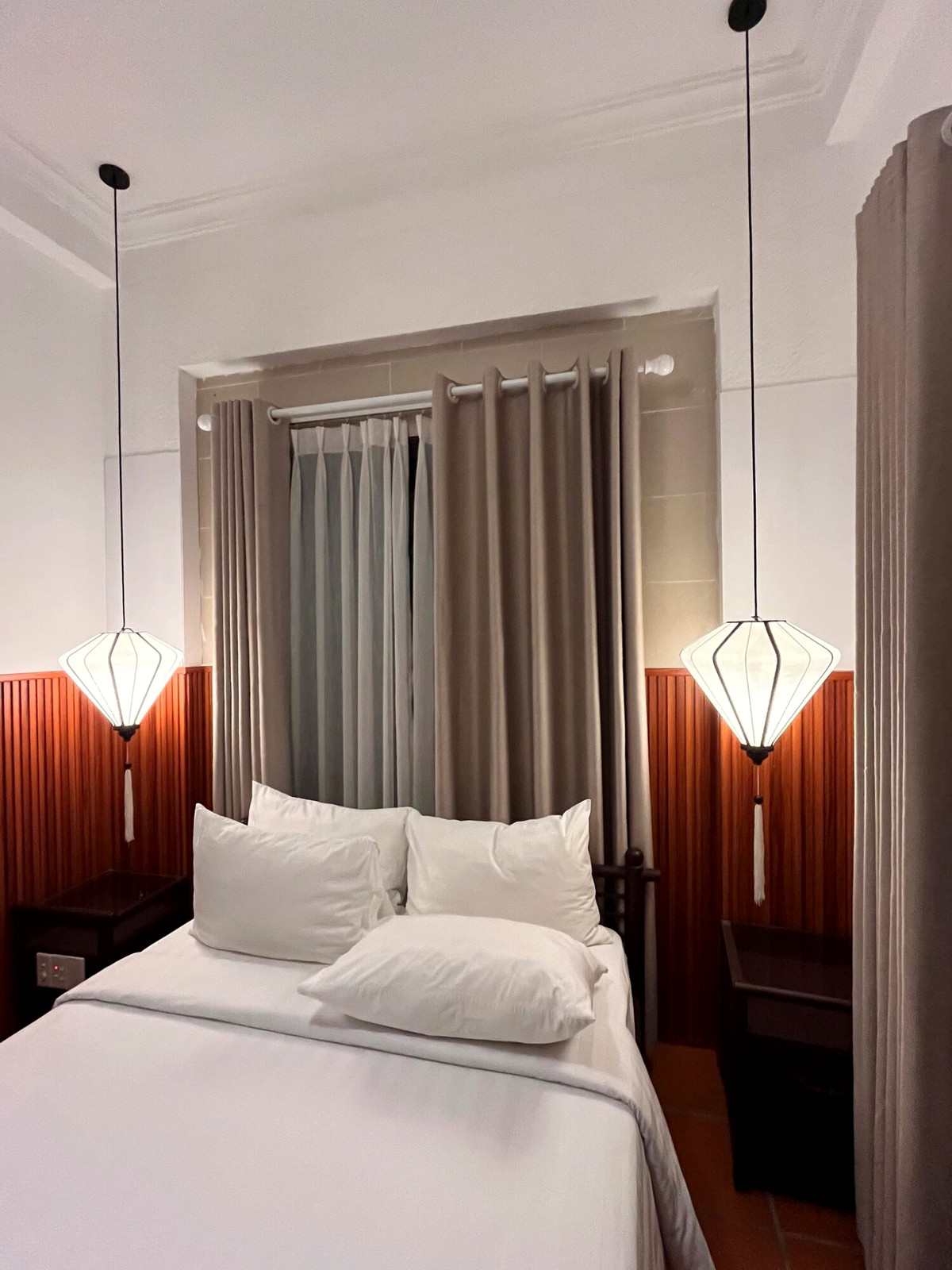 White bed and pendant lamps in the Hoi An hotel room