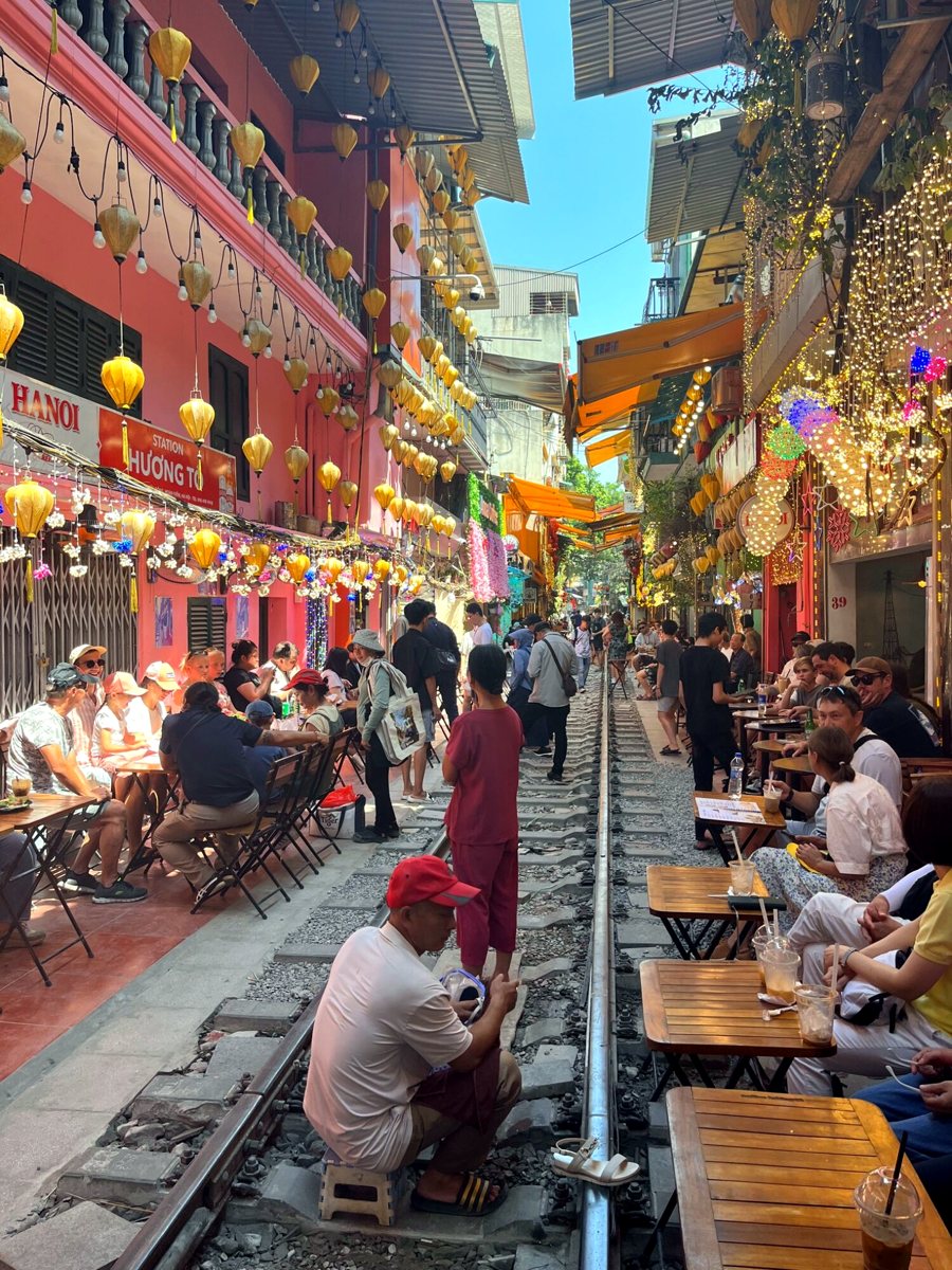 Cafés and lanterns lining the tracks of Hanoi Train Street
