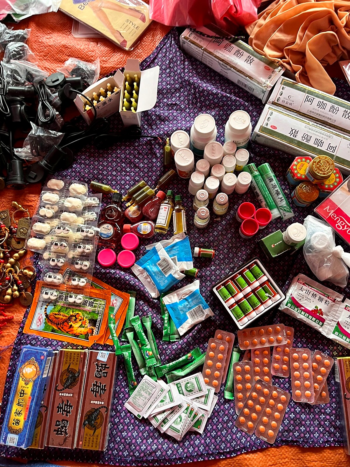 Packets and blister packs of medicine spread across a market stall