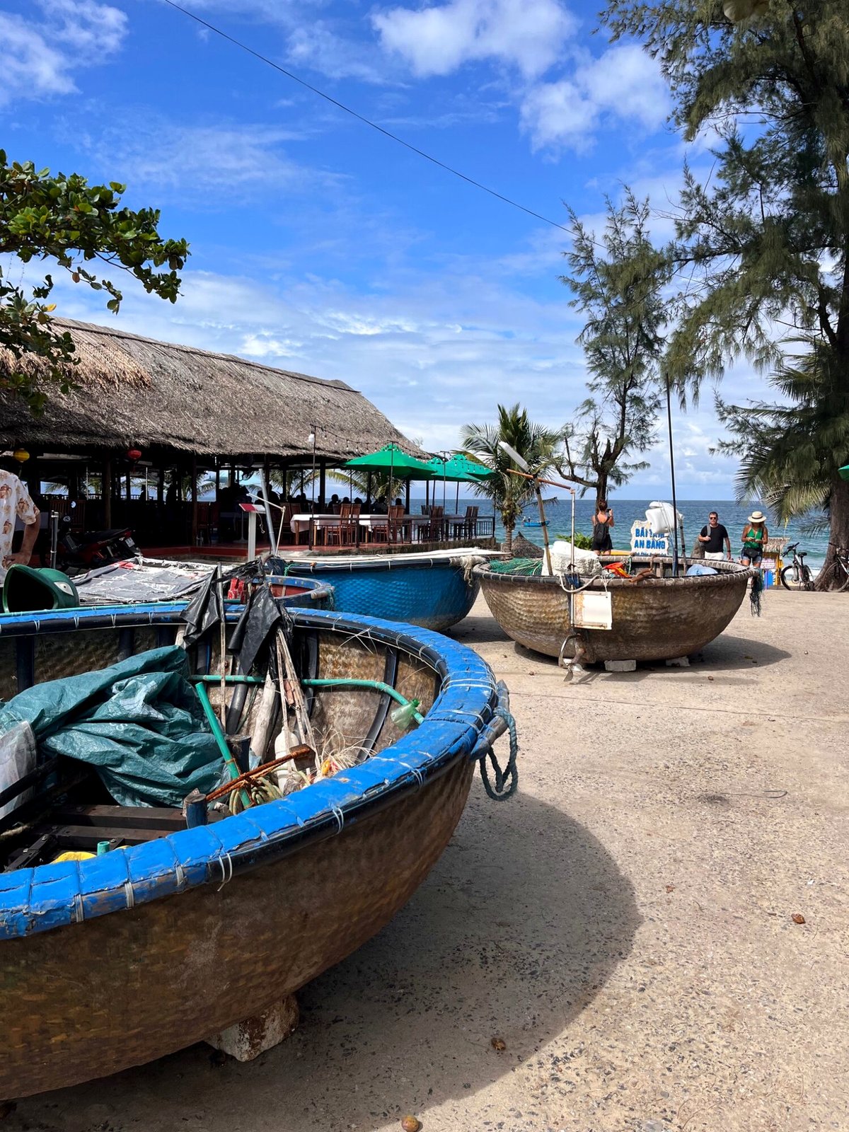 Round basket fishing boats pulled up on the sand at An Bang beach near Hoi An