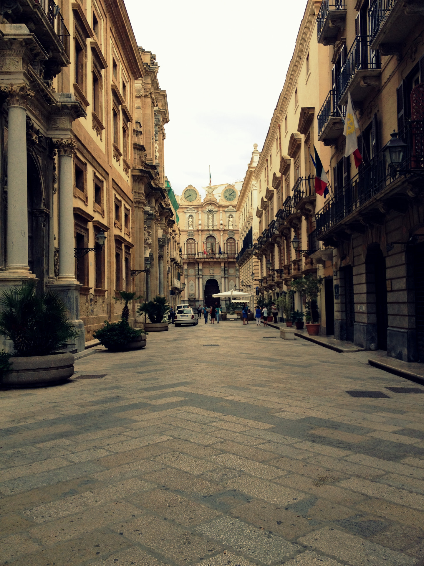 A long historic street in Trapani lined with elegant buildings and balconies