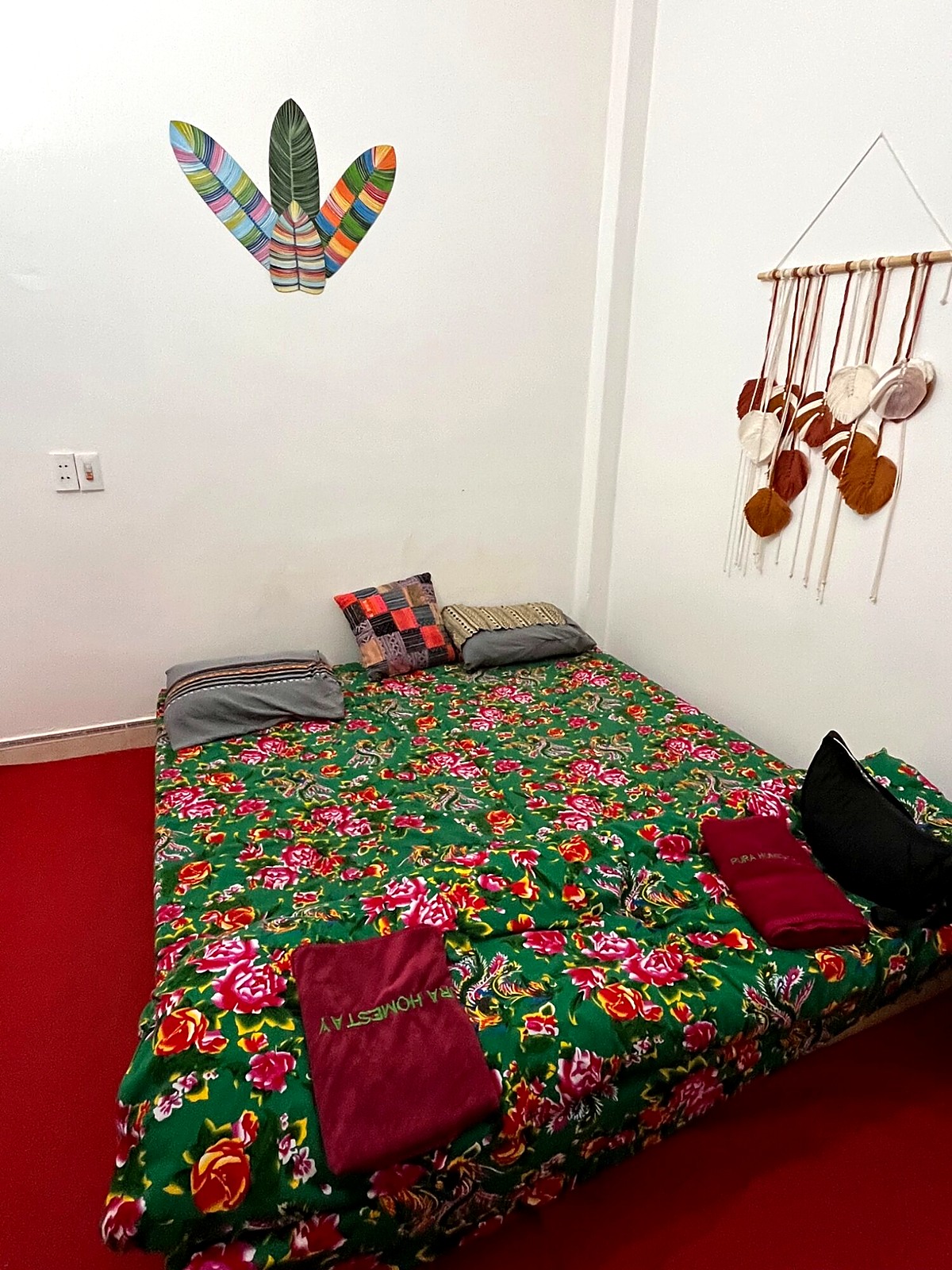 A simple room with a green floral bedspread at a loop overnight stay