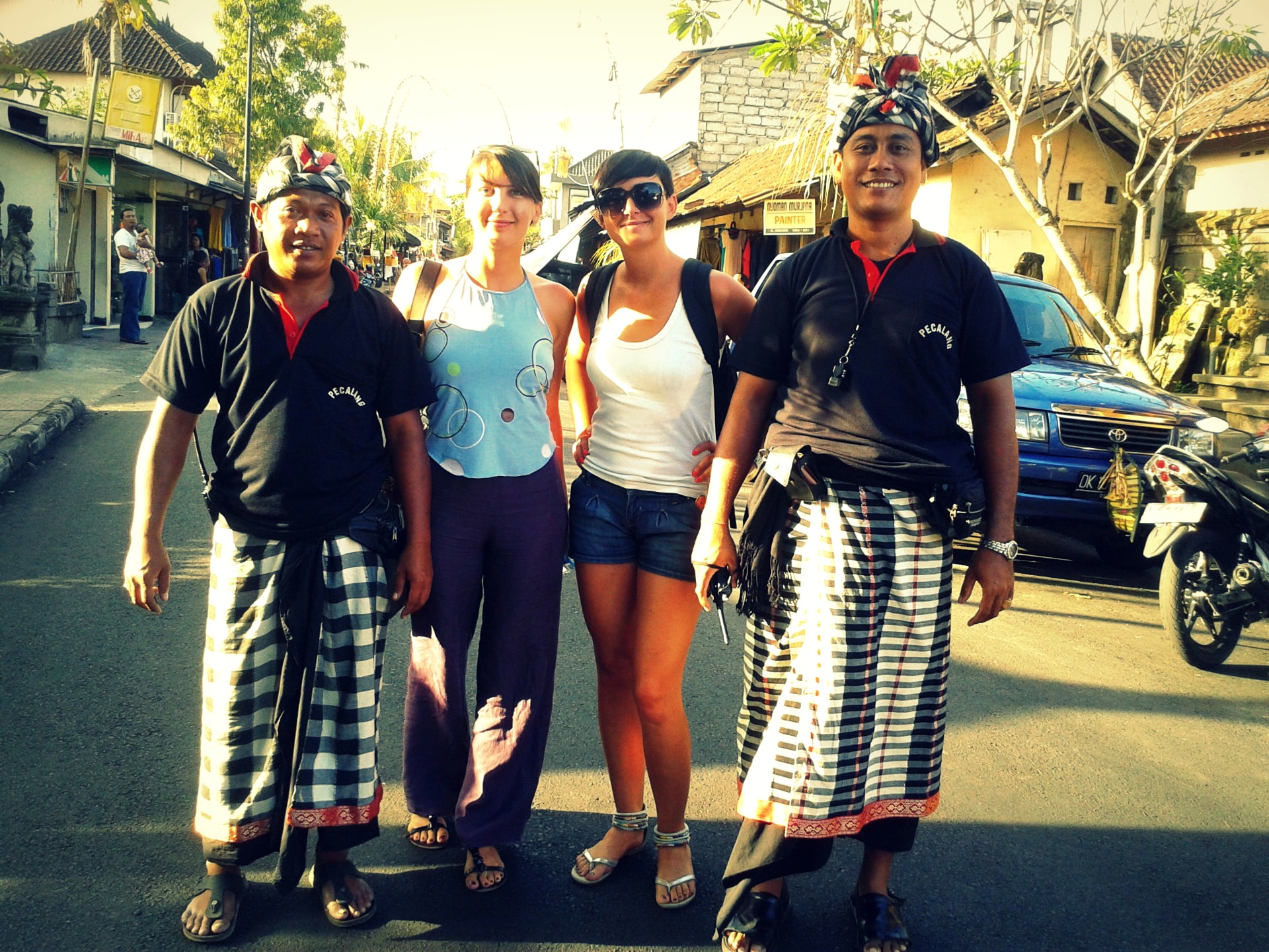 Two travellers standing with Balinese pecalang village guards