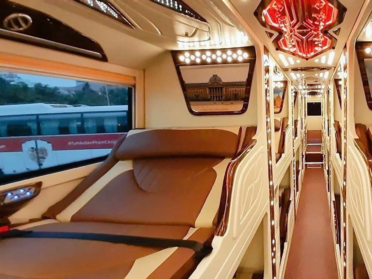 Reclining sleeper berths and a narrow aisle inside a royal cabin night bus