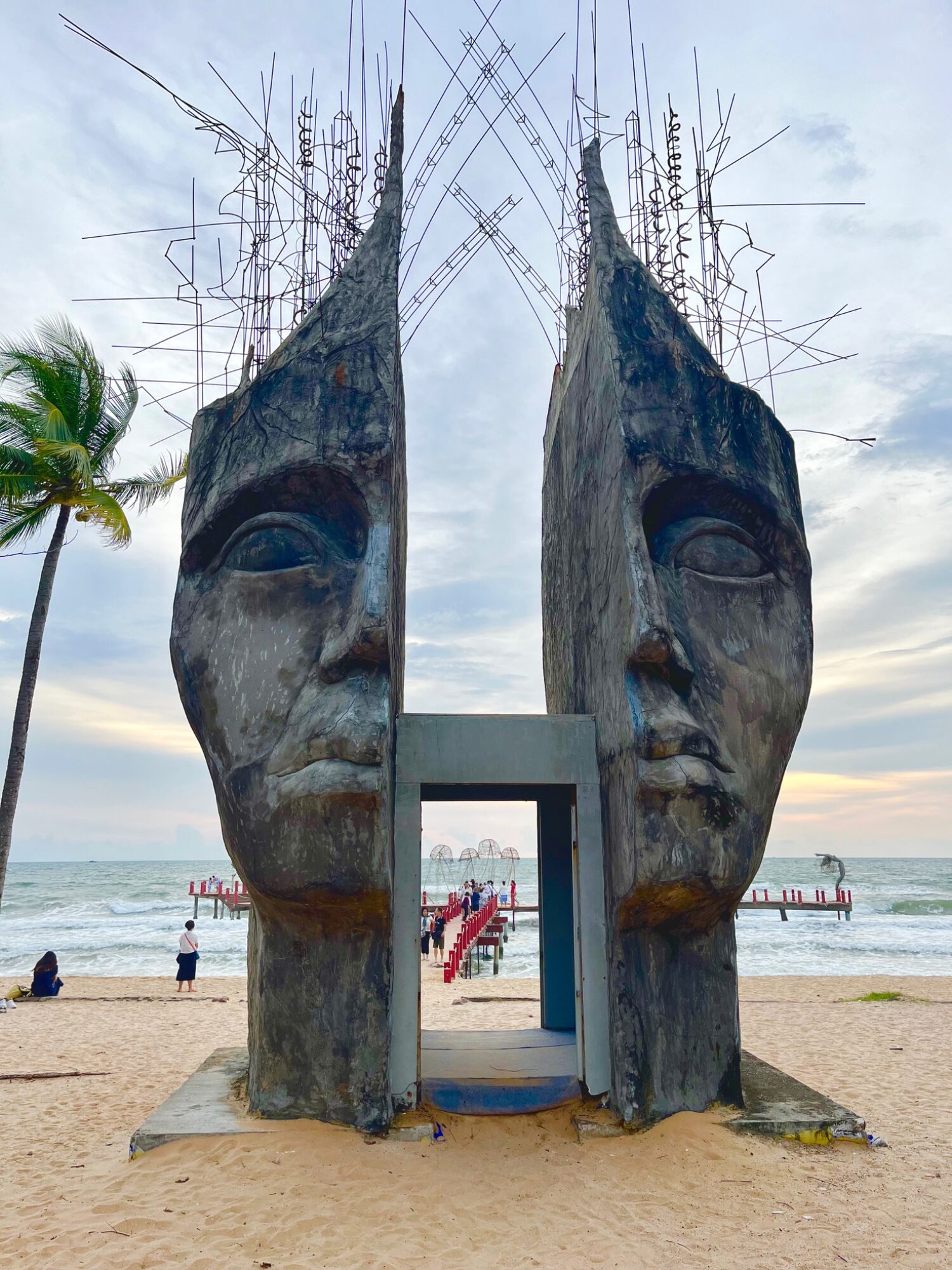 Giant split-head sculpture forming a gateway on the sand at Sunset Sanato Beach on Phu Quoc