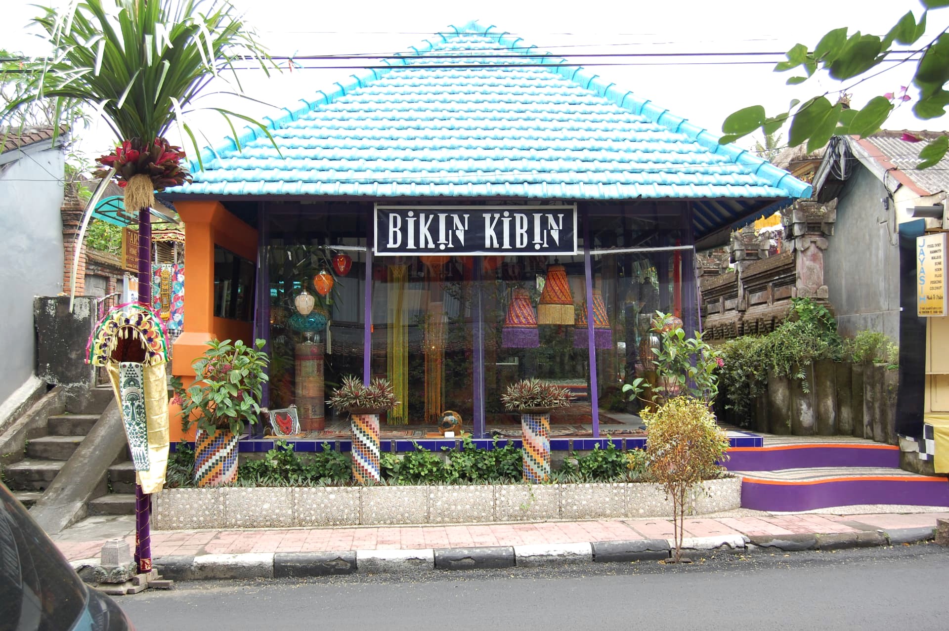 An artisan boutique with a turquoise roof and hanging lanterns in Ubud