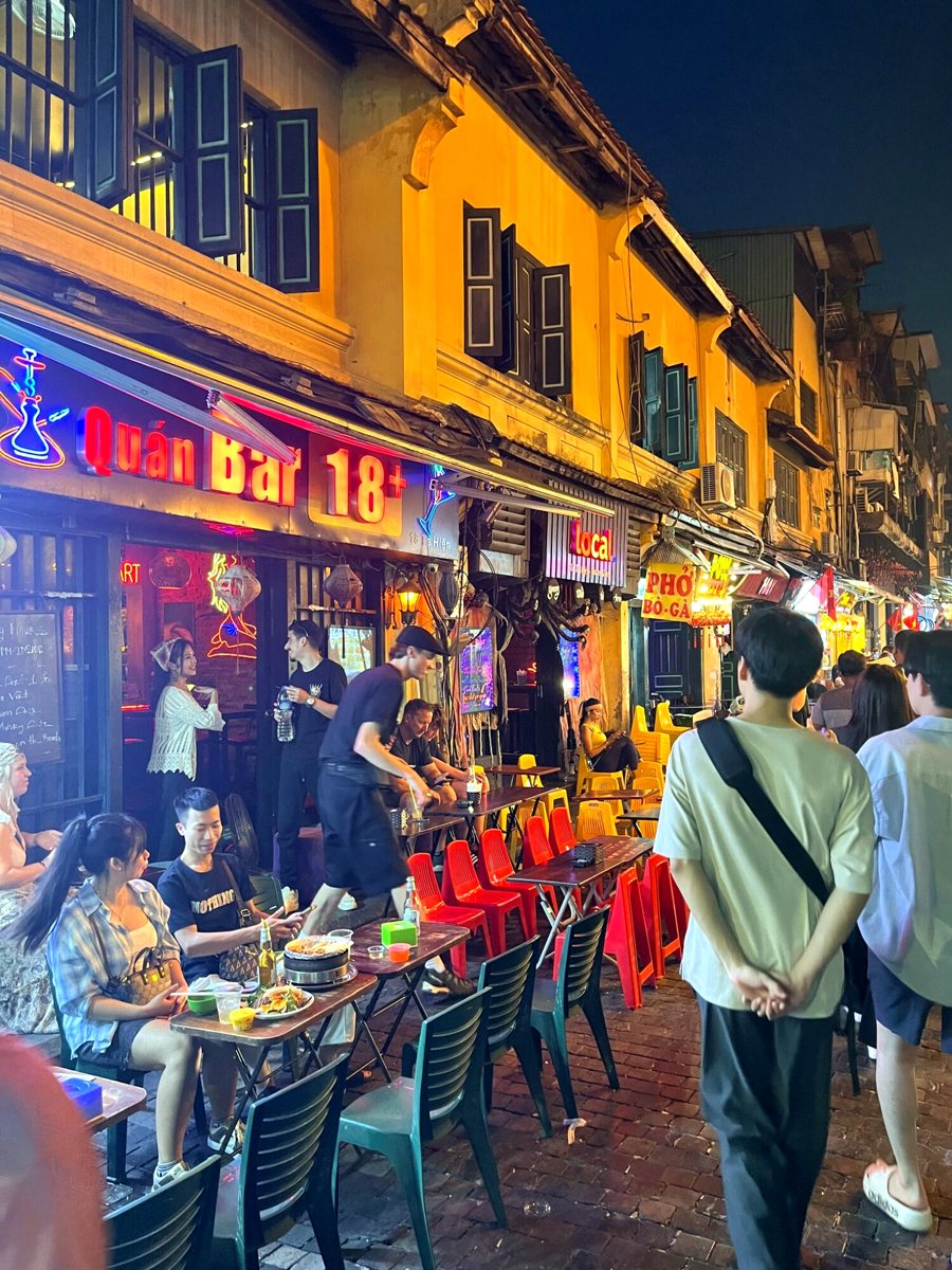 Neon signs and plastic chairs on Hanoi's Tạ Hiện street at night