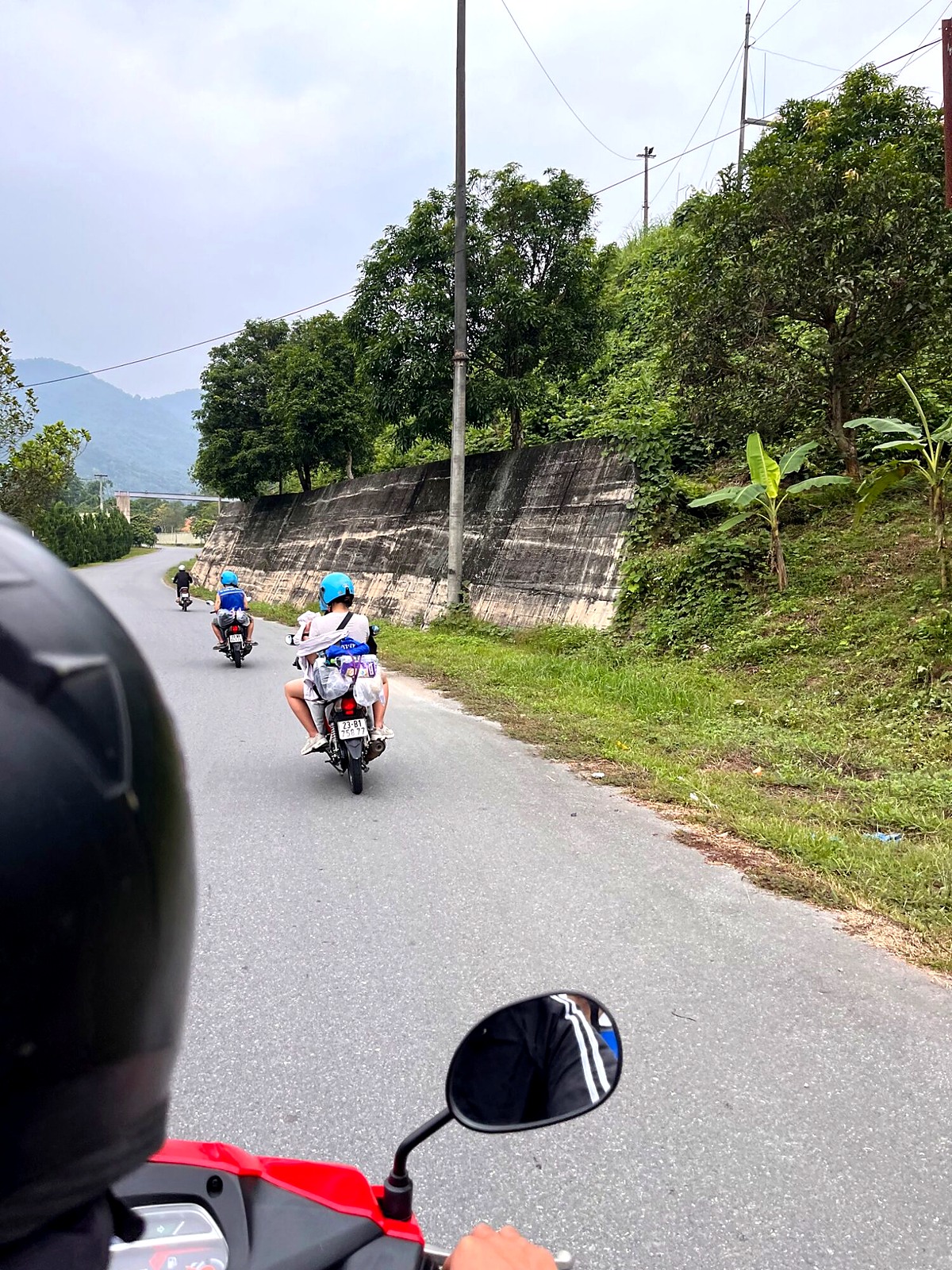 Motorbikes setting off along a road into the Hà Giang mountains