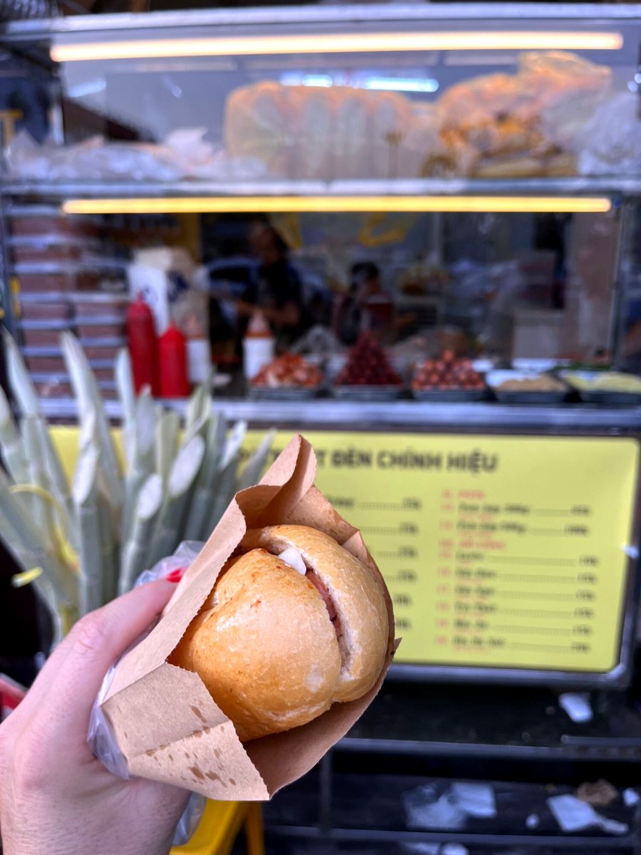 A crusty banh mi held up at a Hanoi street stall