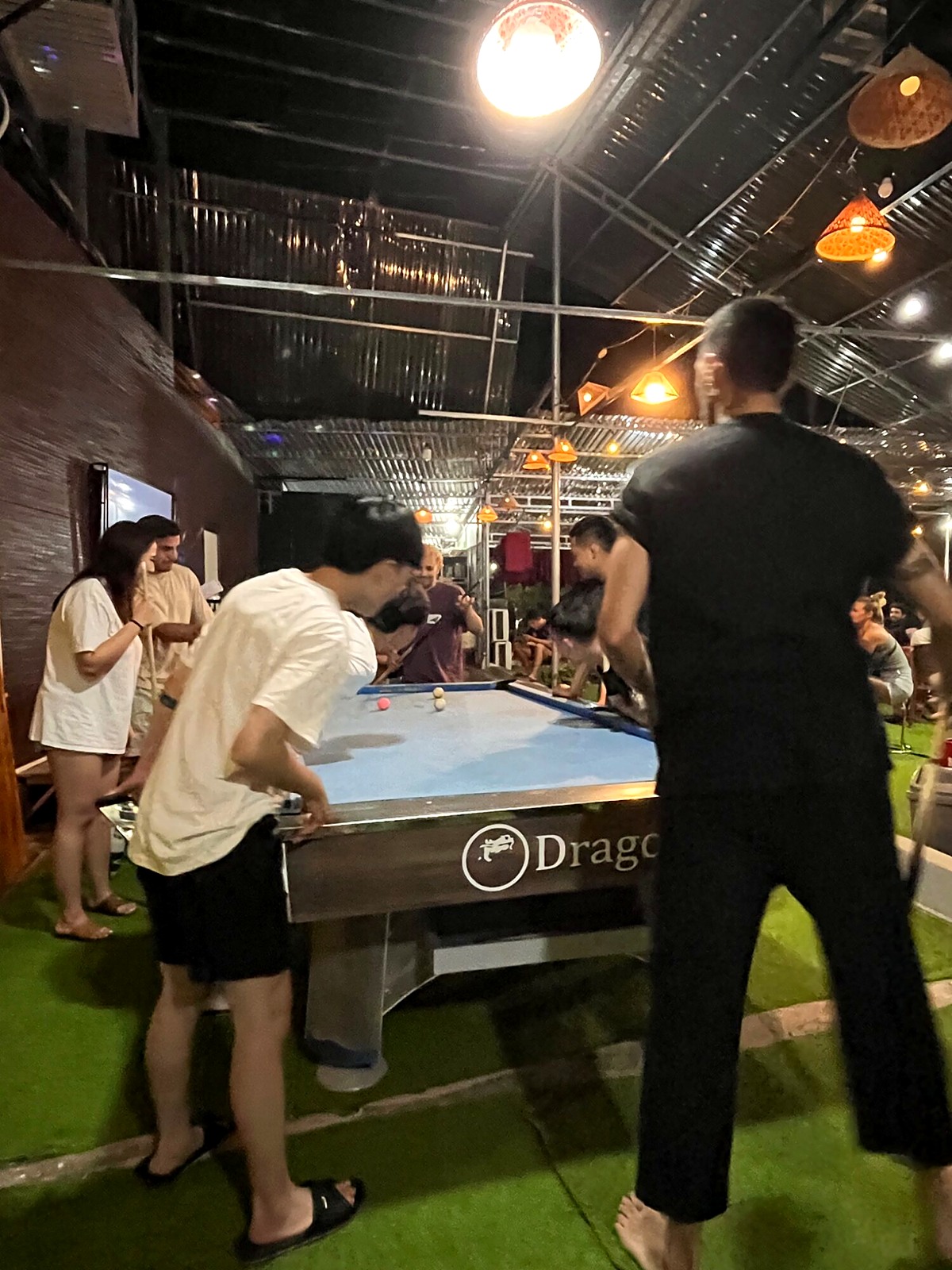 Travellers playing pool indoors at an overnight stop