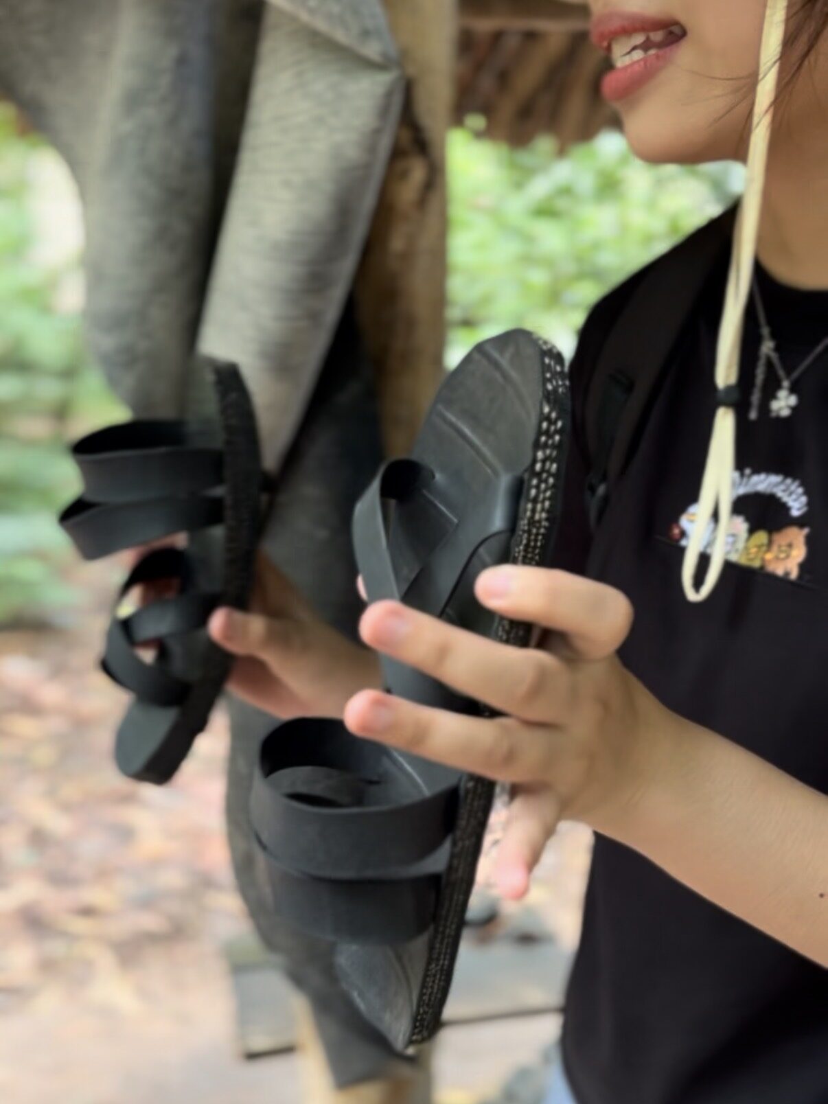 Close-up of black sandals demonstrated during the Cu Chi tunnels tour