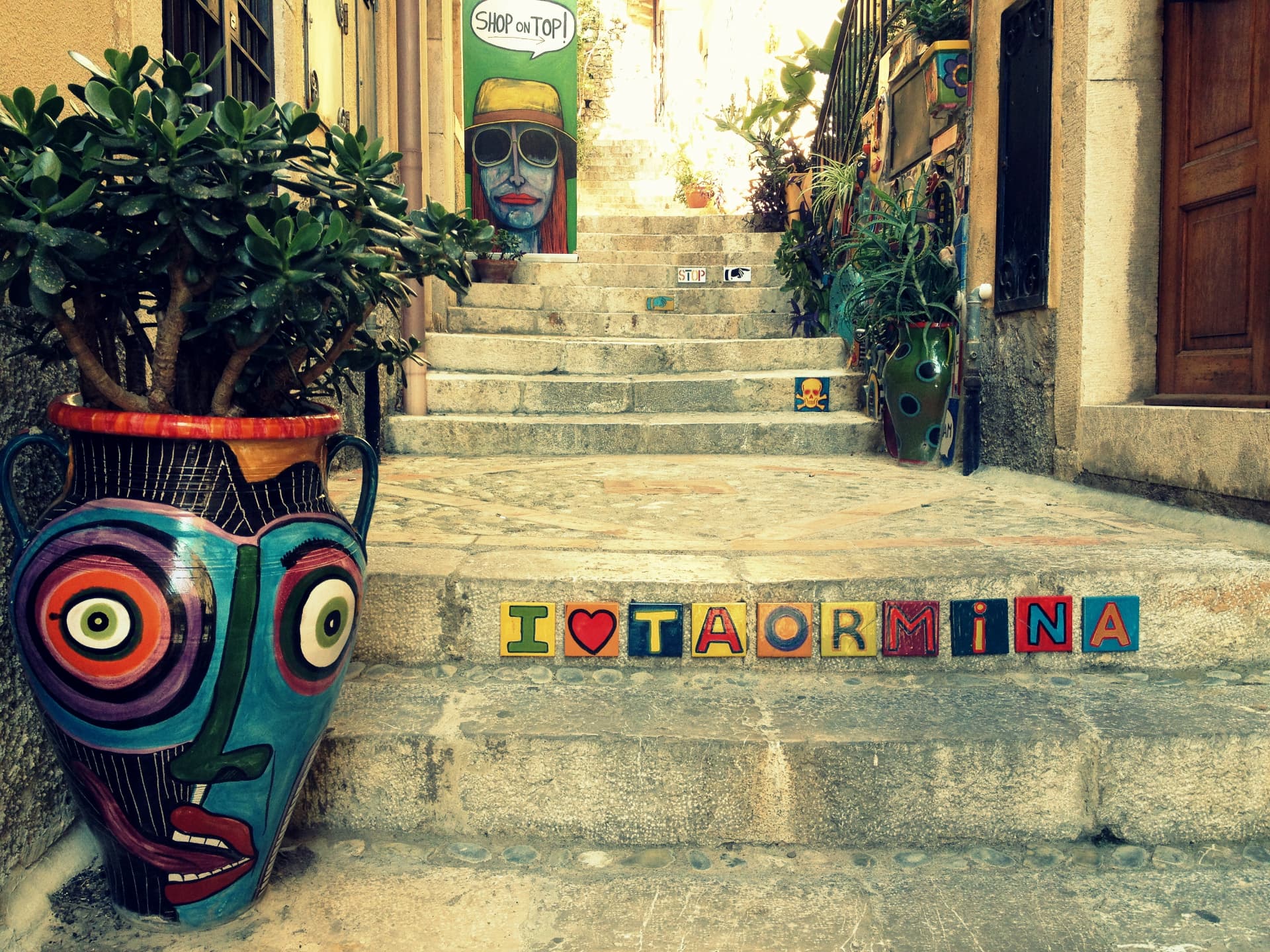 Colourful ceramic pots and decorated tiles on steps in Taormina