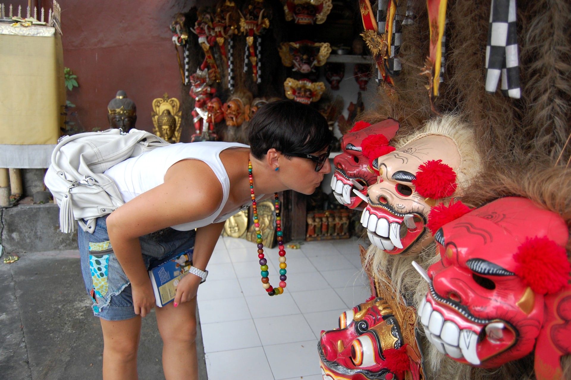 Traveller inspecting hand-carved Balinese masks in an Ubud shop