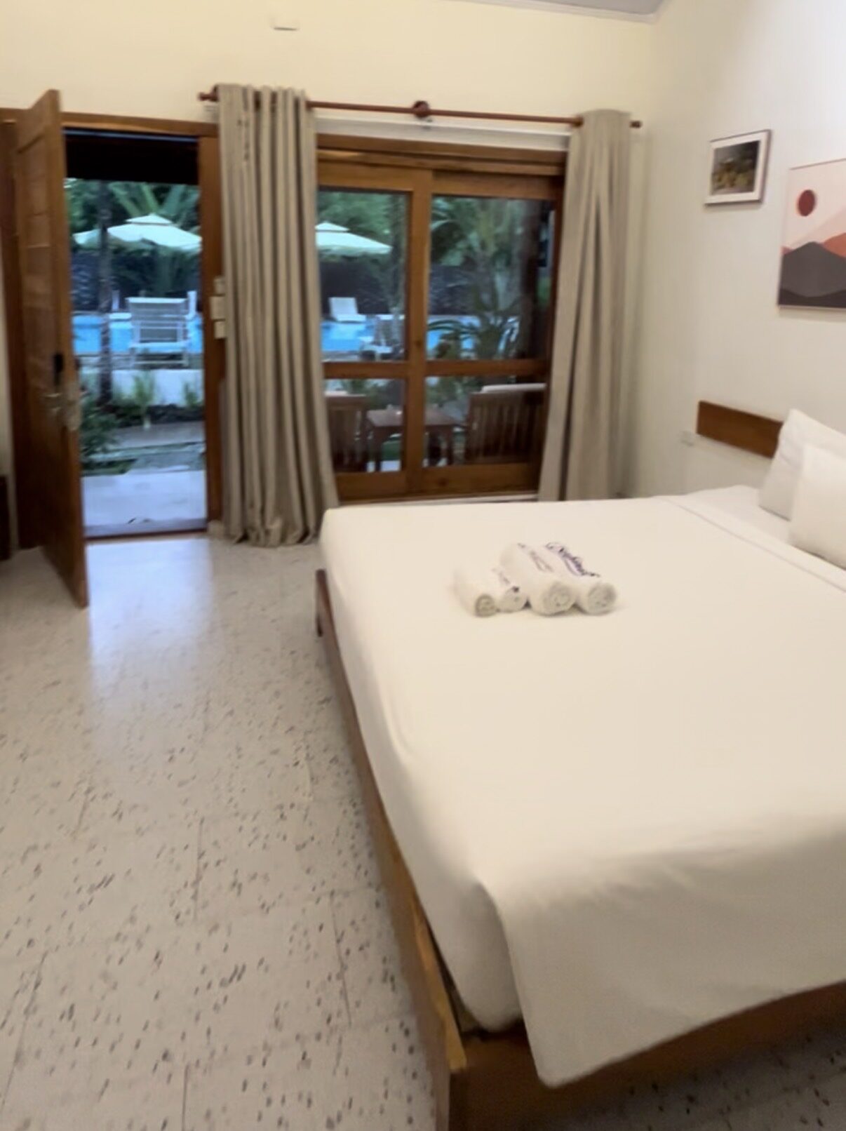 Private resort room with a white bed and garden-facing glass doors