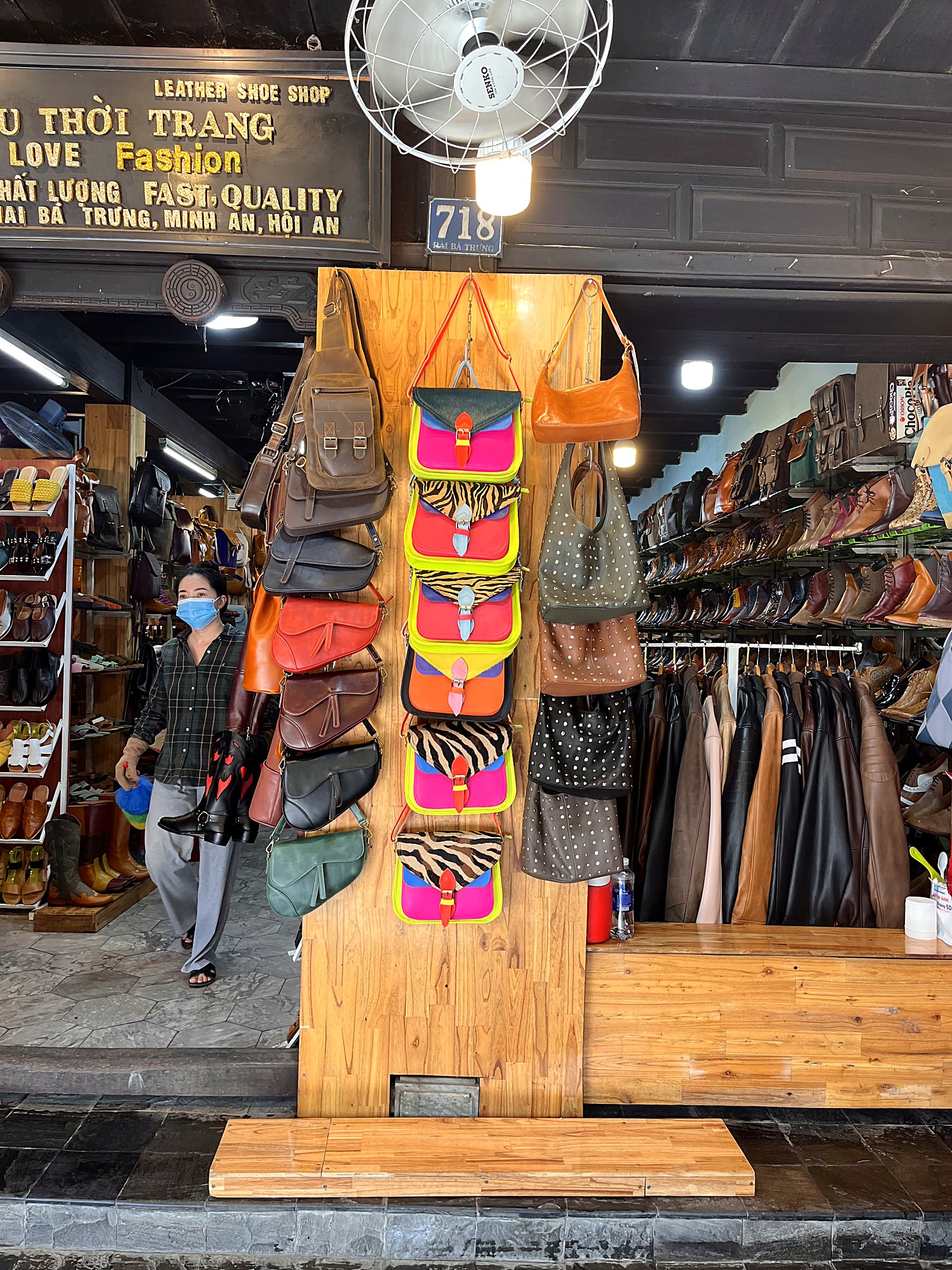 Wall of colourful leather bags and shelves of boots and sandals in a Hoi An leather shoe shop