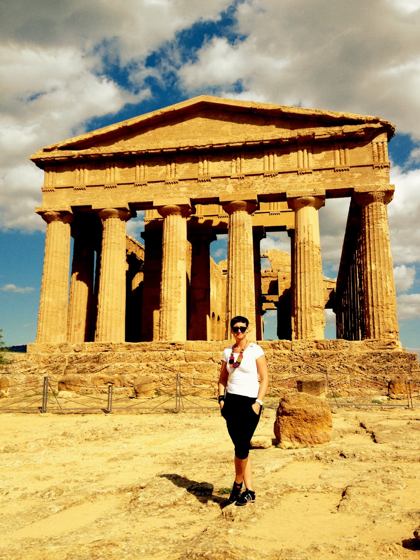 A woman standing in front of the Temple of Concordia at the Valley of the Temples in Agrigento