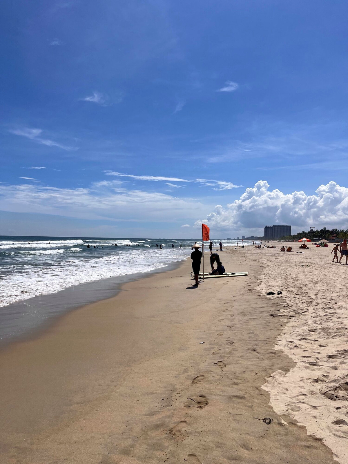 Sunny Da Nang beach with surf, sand and distant mountains