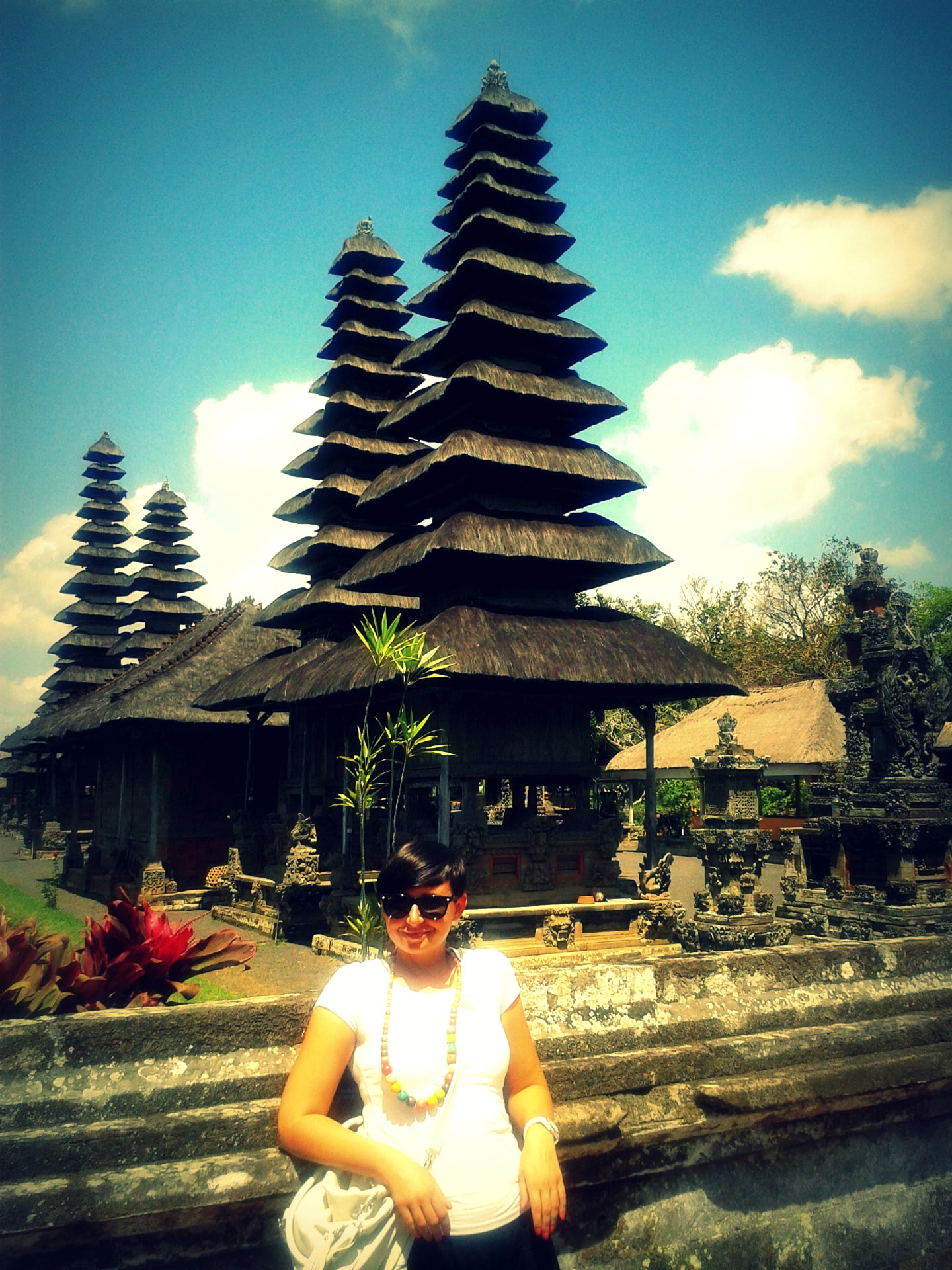 A traveller at Pura Taman Ayun with tiered meru towers behind