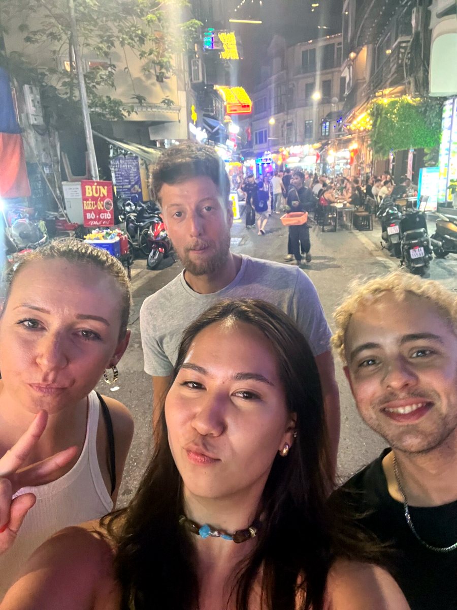 Four friends taking a selfie on a lively Old Quarter street at night