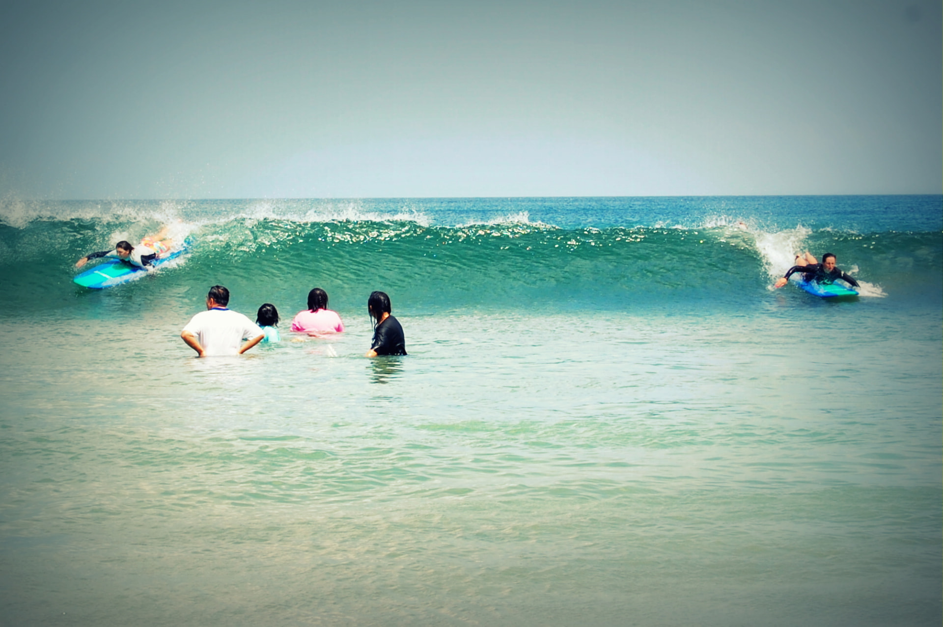 Beginner surfers paddling into a wave at Kuta Beach