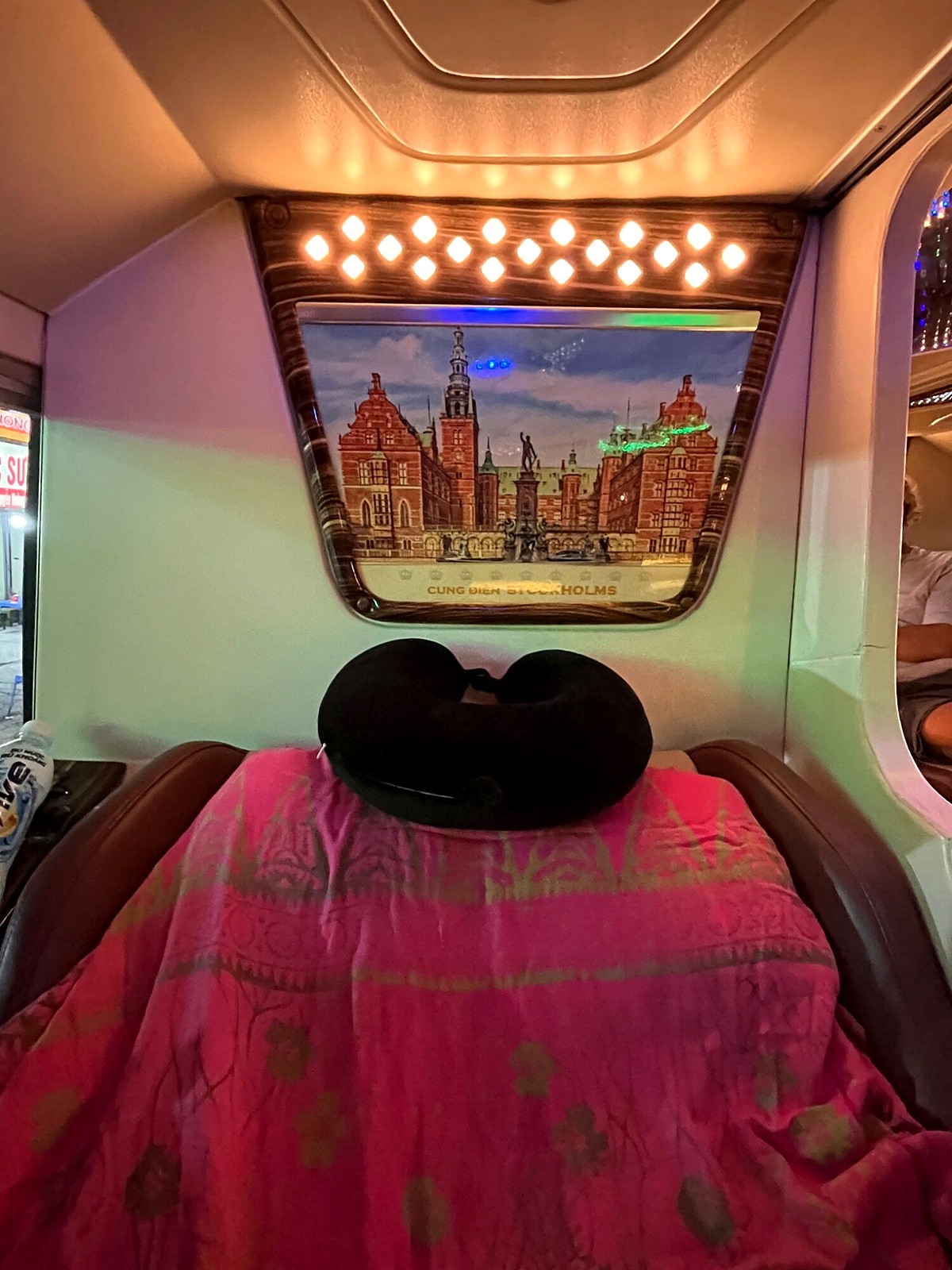 A private sleeper-bus berth with a pillow and blanket