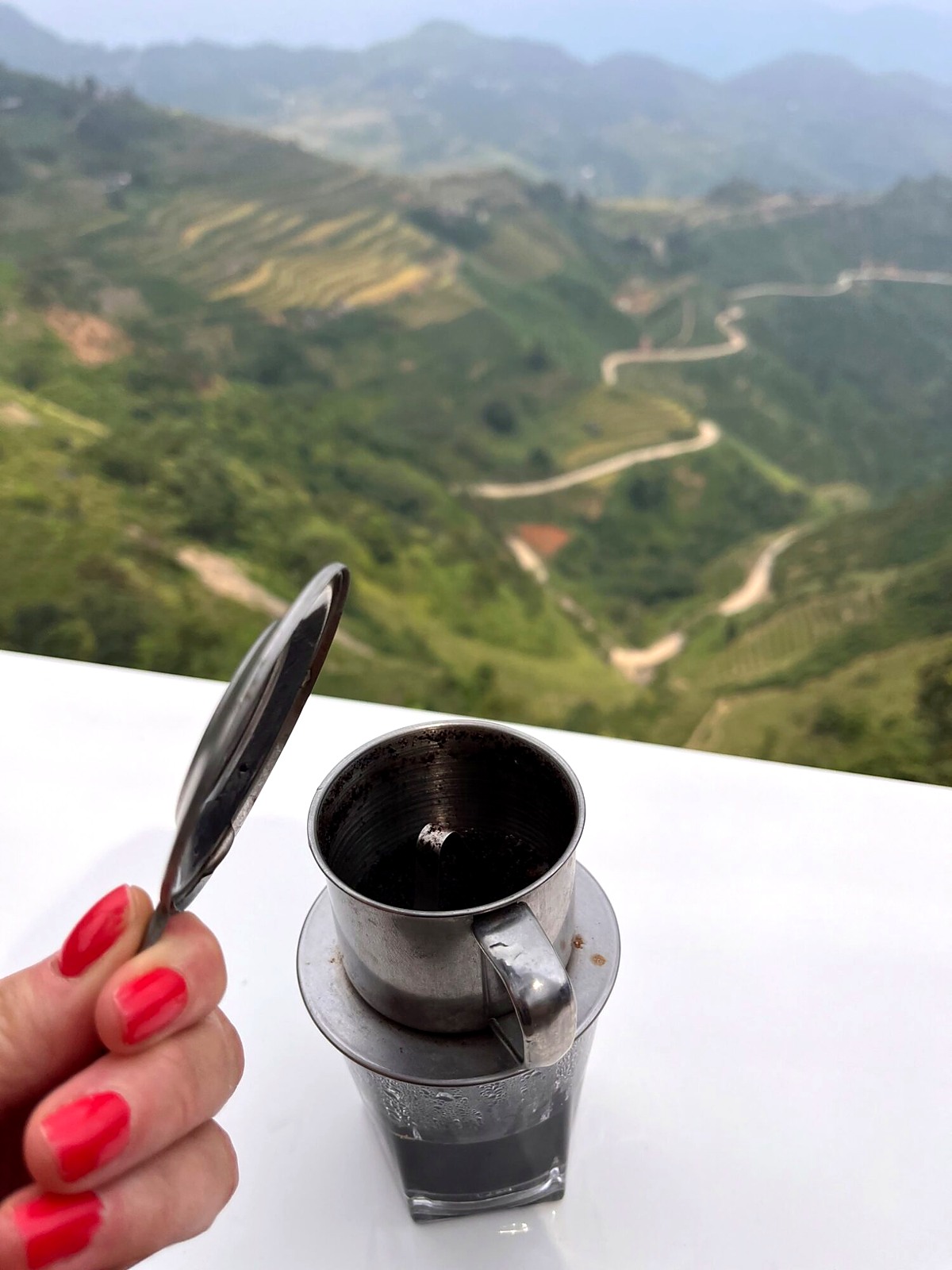 Vietnamese black coffee overlooking a winding mountain road