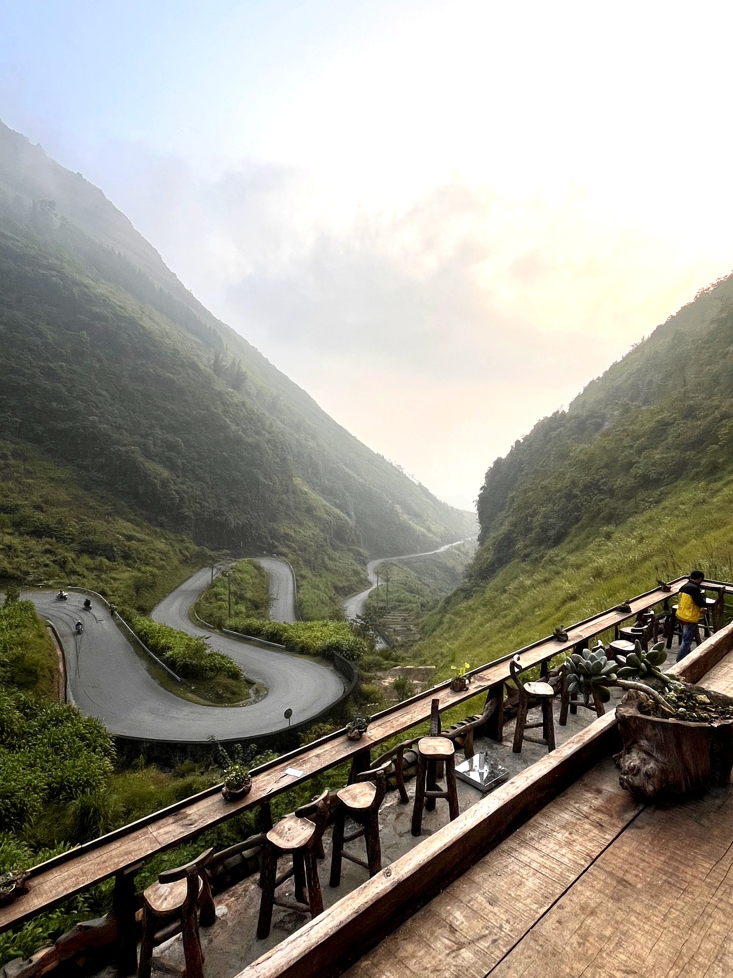 Winding mountain road through a green valley on the Hà Giang Loop
